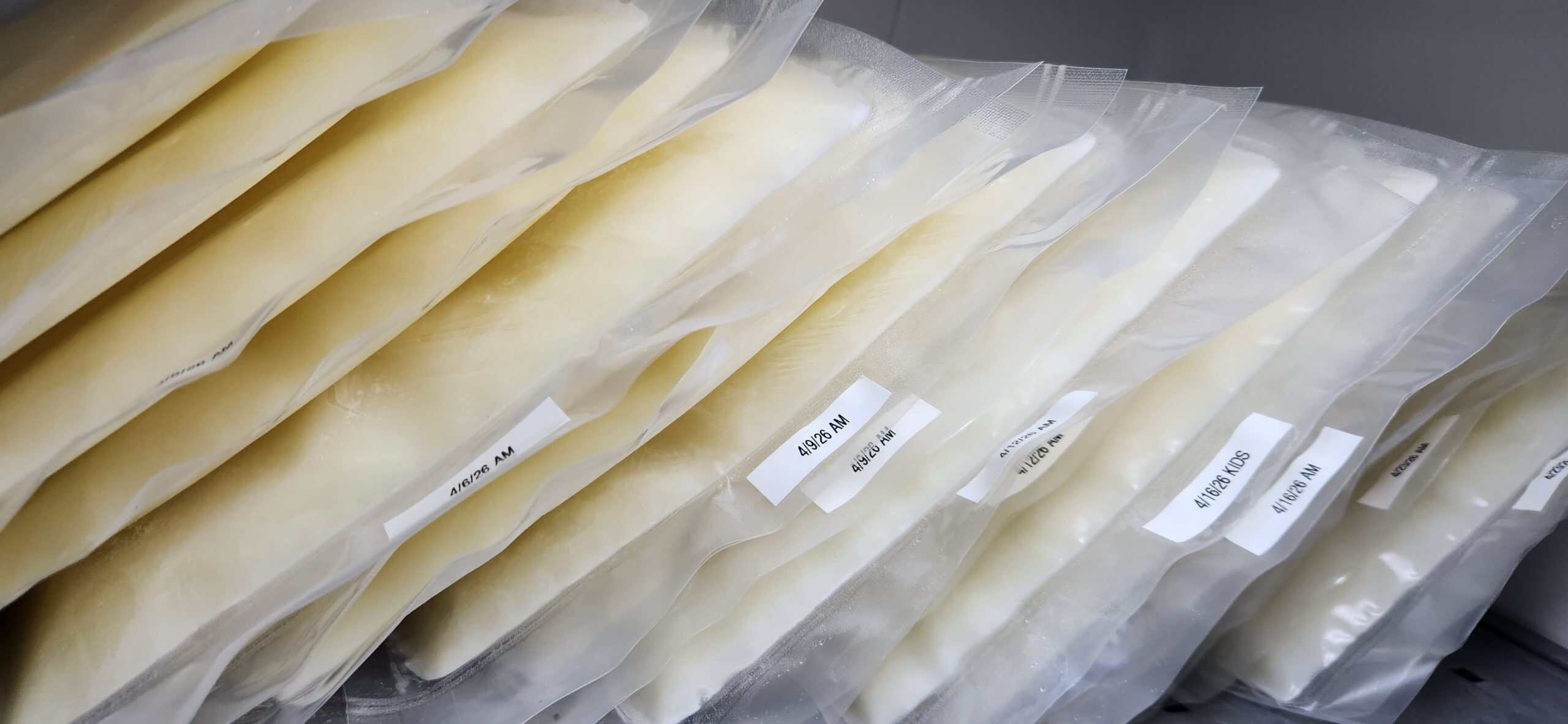 frozen goat milk stacked vertically with date labels